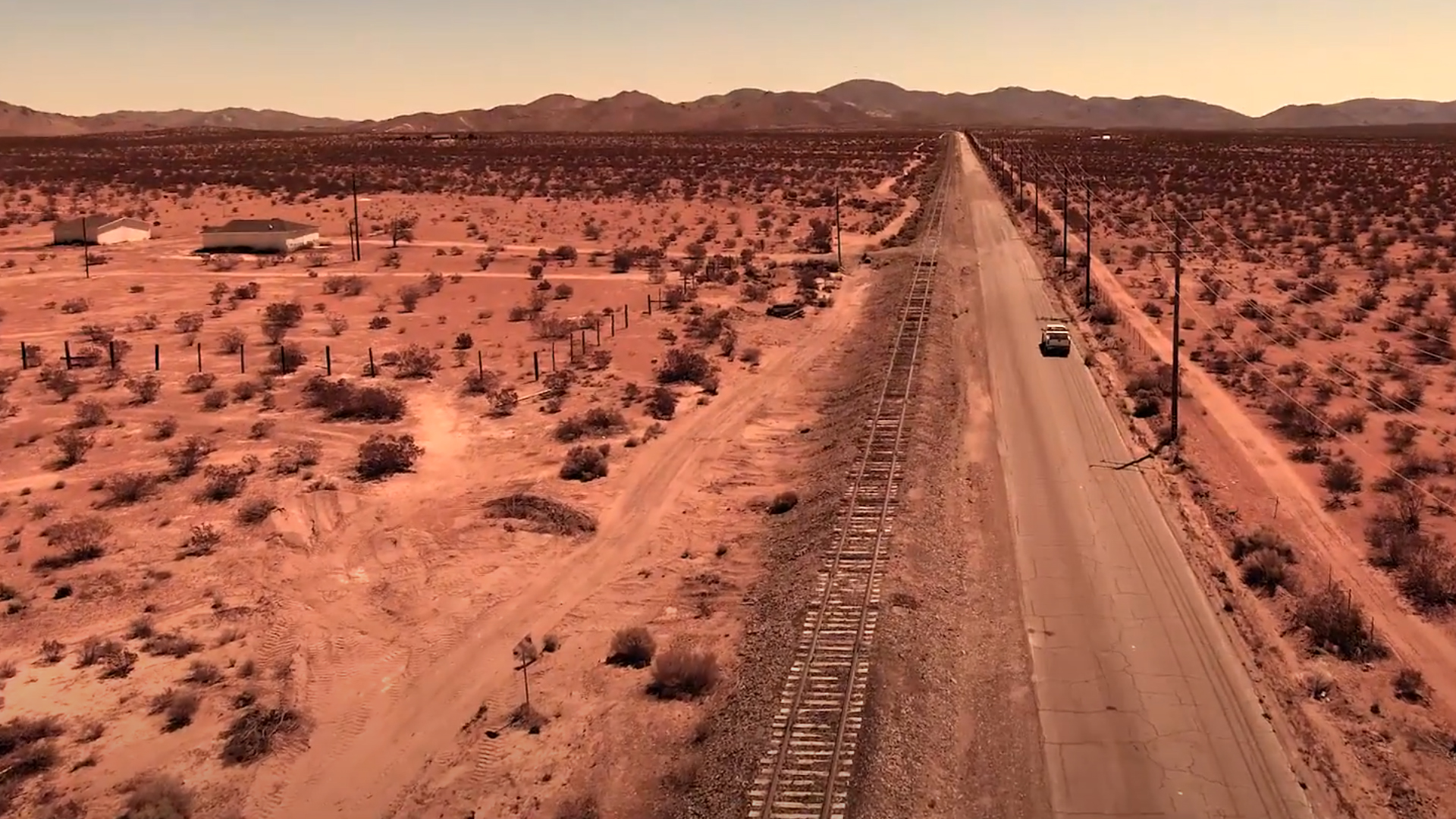 Desert drone shot of road and railroad tracks
